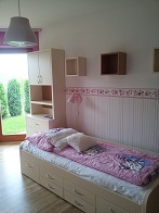 Finální realizace interiéru dětského pokoje, záběr na postel, stůl a skříň